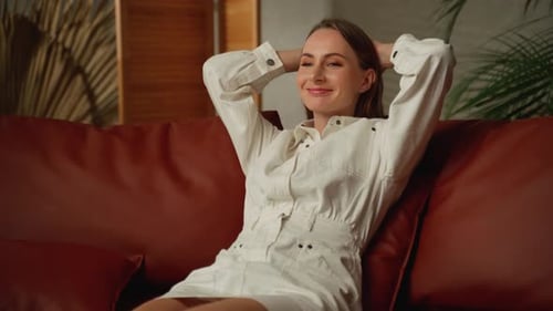 Woman Relaxing on Sofa in Bright Living Room