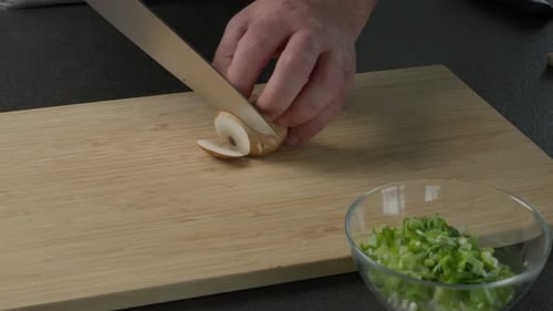 Chef Slicing Mushroom on a Wooden Cutting Board