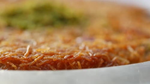 Kunafa avec une lingette en crème sur une assiette