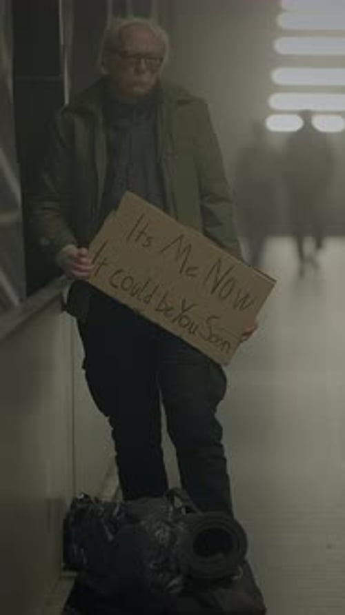 A Man in a Dim Corridor Holds a Sign Expressing His Struggles Evoking Urban Lifes Complexities