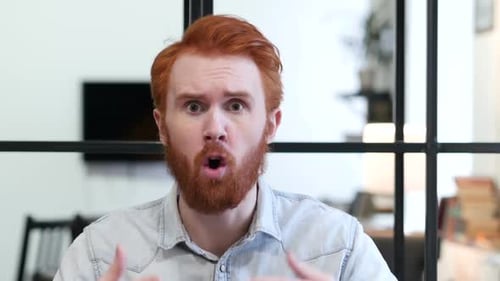 Man Arguing, Frustrated, with Red Hair in Office