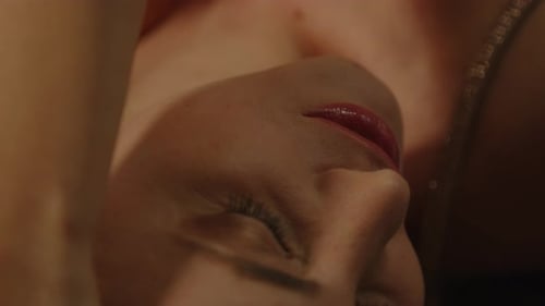 Extreme close up of a beautiful woman sensually caressing her face and softly moaning in joy