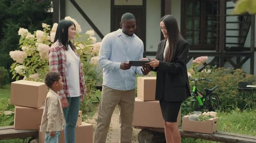 Asian Female Real Estate Agent Selling a House to a Multiethnic Family African Dad Caucasian Mom