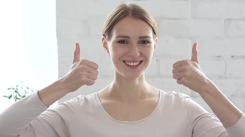 Young Adult Gives Two Thumbs Up Smiling