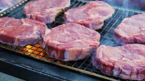Raw Beef Steak is Being Roasted on the Grill Pan Outdoors