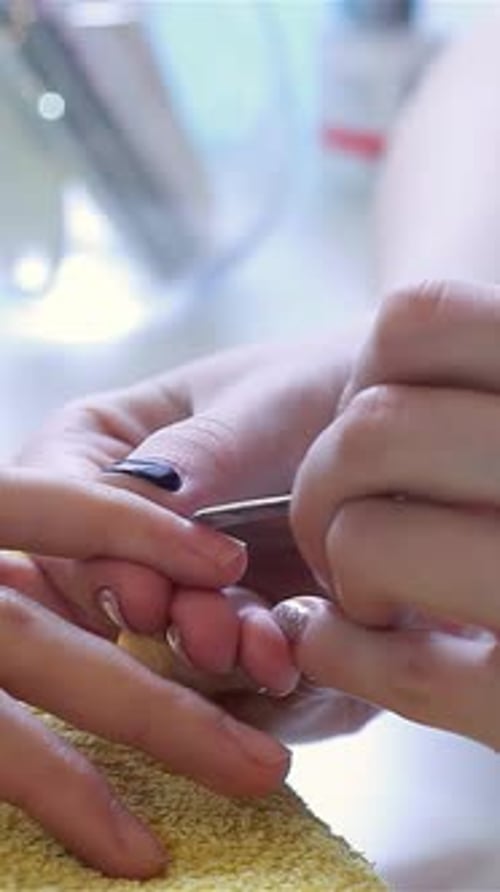 Expert Manicurist Meticulously Tending to Client's Cuticles with Precision Tools
