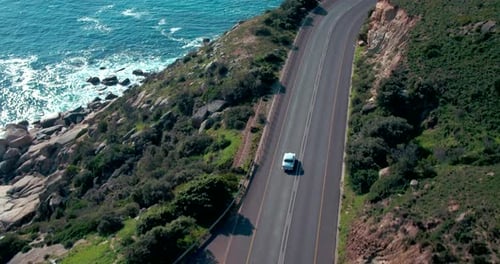 4k drone footage of a car driving on the road near the coast
