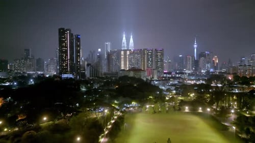 Aerial fly over green field in KL city
