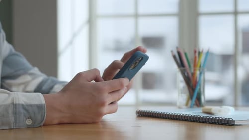 Hands Boy benutzt Smartphone im Wohnzimmer zu Hause, Seitenansicht