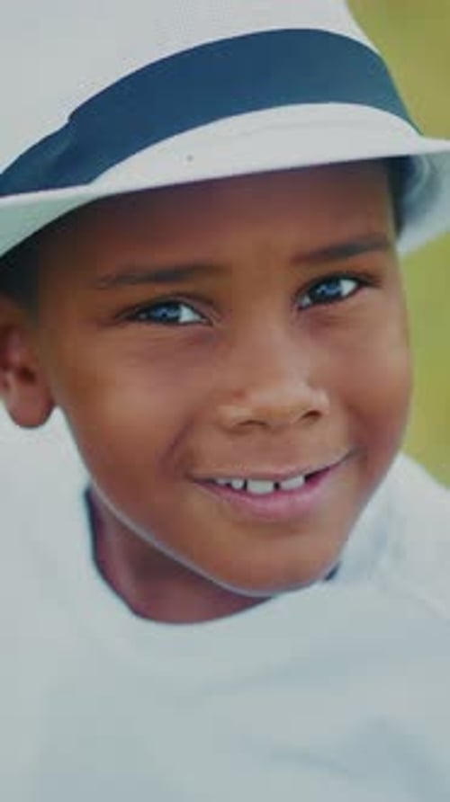 Young Child Explores a Grassy Field While Wearing a Hat on a Sunny Day