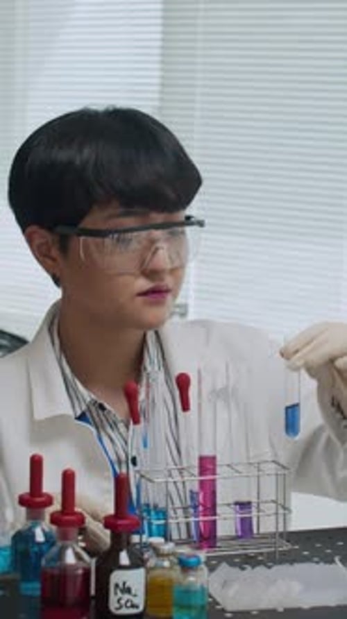 Young Scientist Examines Test Tube in Laboratory