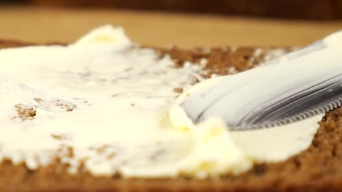 Butter Being Spread on a Slice of Bread