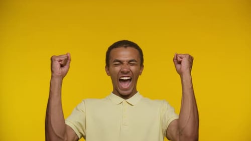 Excited Man Cheering on Bright Yellow Background