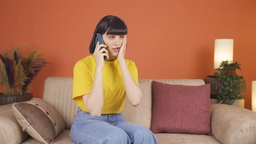 Woman getting bad news on the phone gets upset.