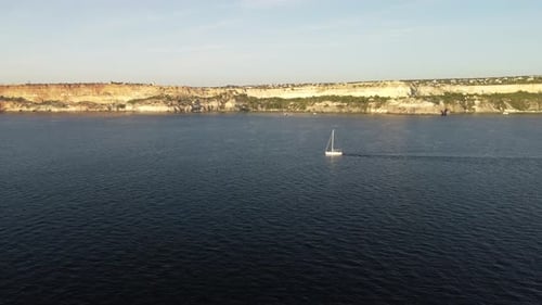 Aerial View of a Luxury Sailing Ship with White Sails in the Sea in the Evening Sunlight Luxurious