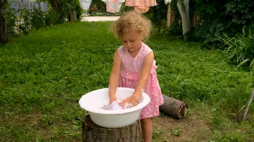 The Child is Washing Clothes in the Garden Selective Focus
