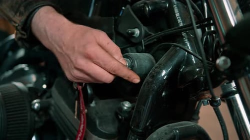 Creative authentic motorcycle workshop Garage biker mechanic inserting the key into the power start