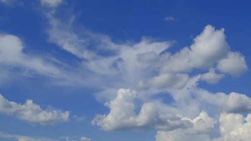Fluffy White Clouds Moving Across a Blue Sky