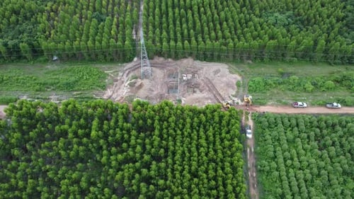 Aerial view of excavators are working on the foundations of high-voltage pylons.