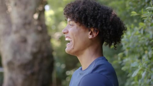 Smiling Young Man Laughing Outdoors in Nature