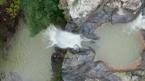 Waterfall with Rain and Snow waters plummeting down the stream, surrounded by lush green nature