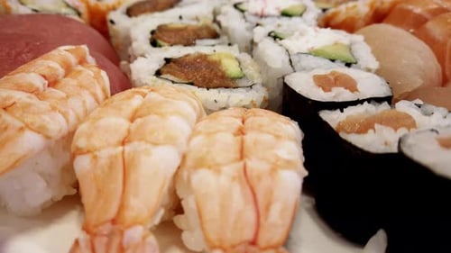 sushi variety arranged on a plate and rotating under a close-up camera view with colorful detailed p