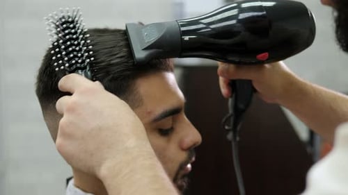 Man Receives Hair Styling Service at Barber Shop