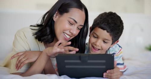 Mother and Child Using Tablet Device on Bed