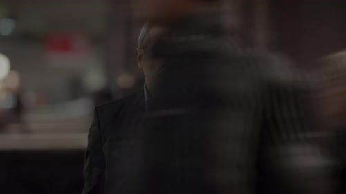 Man Standing in Busy Urban Environment at Night