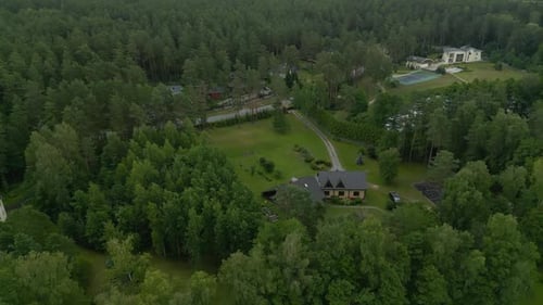 An Aerial View of a House Between Green Trees