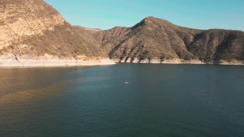 Aerial drone flying over a lake, water dam, with mountains at sunrise. Beautifull dreamy landscape v