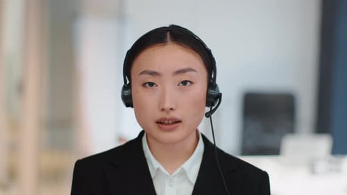 Camera Pov Portrait of Professional Young Asian Woman Support Center Operator Wearing Headset