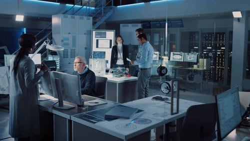 Scientists collaborating at computers in futuristic laboratory