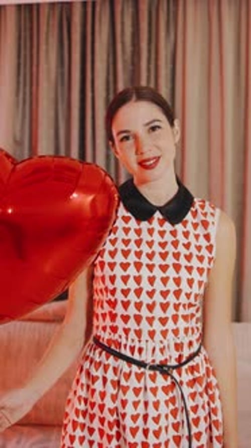 Woman Smiling Holding Red Heart Shaped Balloon