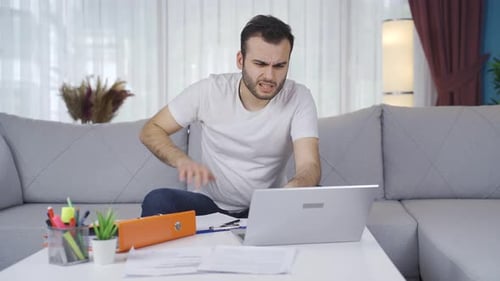 Stressed Man Working on Laptop From Home