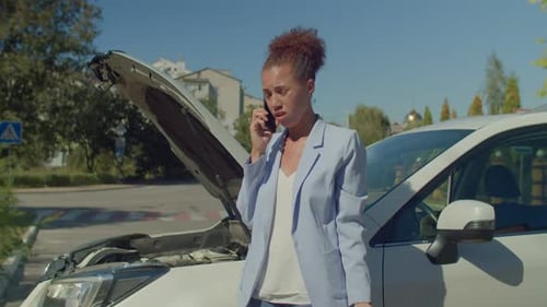 Upset Lovely Black Female Calling Roadside Assistance Near Broken Car in City
