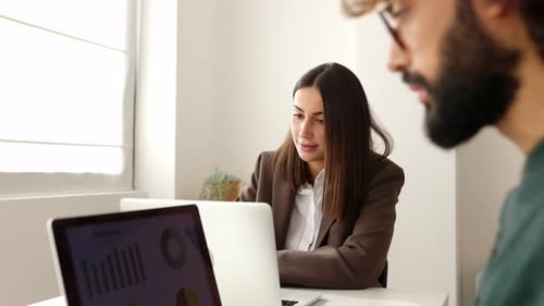 Two Confident Business People Working on Laptop in the Office