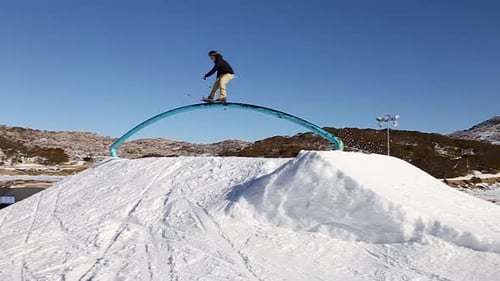 Slow Motion Snowboarder And Skiier Grinding On Snow Park Rail Trick