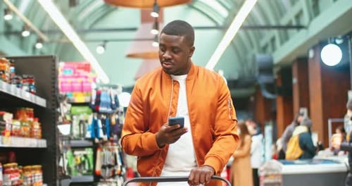 Handsome Male Customer Choosing Products in Supermarket Young AfroAmerican Guy with Cart Ckecking