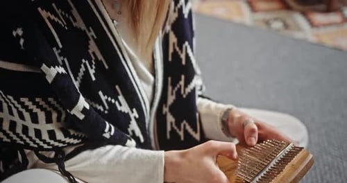 Woman Playing Kalimba in Relaxed Setting