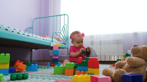 Cute Baby Girl Playing with Blocks in Bedroom