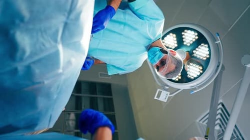 Surgeons Performing Operation Under Bright Surgical Light