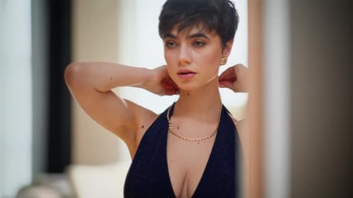 Elegant Woman Adorns Herself with Gold Necklace