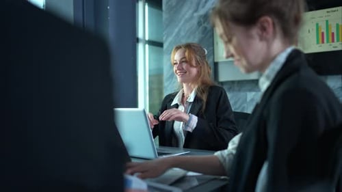 Professional Women Discuss Business in Modern Office