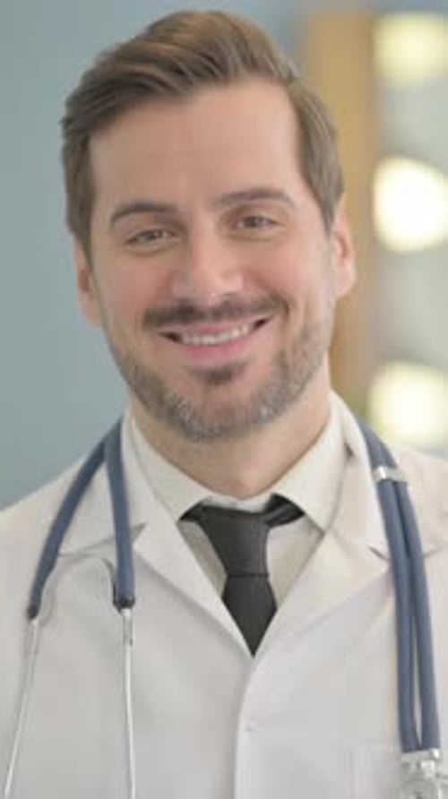 Portrait of Smiling Male Doctor in Clinic, vertical video
