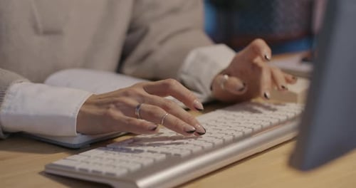 Closeup of Female Hands Typing with Keyboard While Businesswoman Working with Computer in Office in