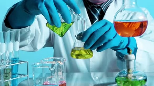 Scientist s Hands Expertly Mix Glowing Green and Yellow Chemical Solutions