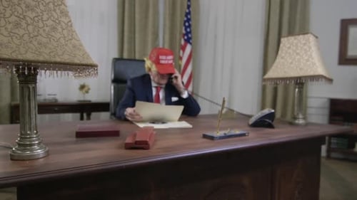 Adult Talking on Telephone at Desk with Flag