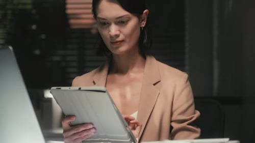 Young Businesswoman Using Tablet at Office Working at Night