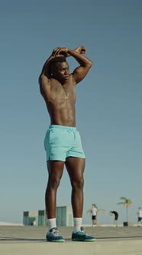 Man Stretches Arms Outdoors in Sunlight